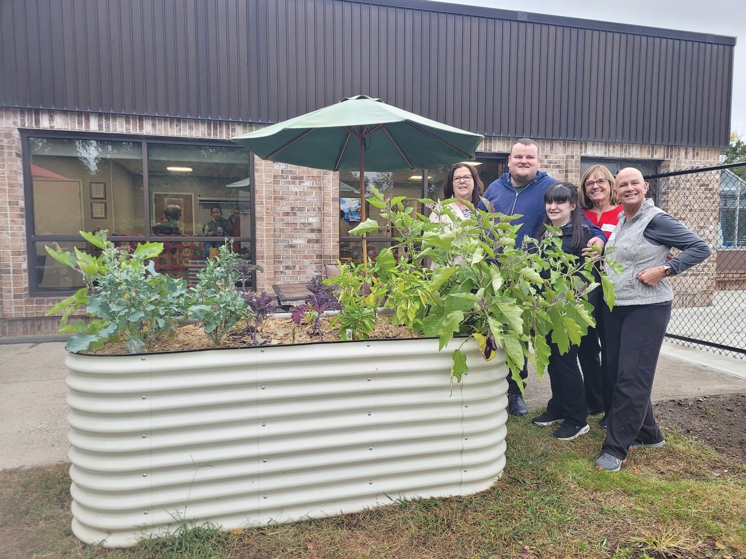 SEEDING SUCCESS: From left to right, The Autism Project (TAP) Executive Director Joanne G. Quinn, Unity Community members Patrick Quinn and Nicole Cadick, and TAP lead facilitators Lore Gray and Lisa McKay, pose for a photo behind the elevated planters outside the organization’s Atwood Avenue headquarters.
